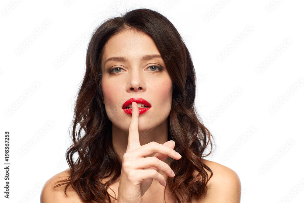 beauty, secret, make up and people concept - woman holding finger on lips or mouth with red lipstick over white background beauty, secret, make up and people concept - woman holding finger on lips or mouth with red lipstick over white background