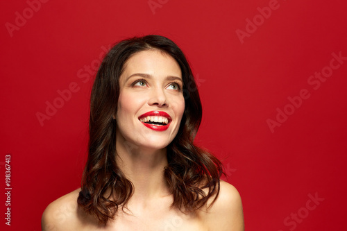 beauty, make up and people concept - happy smiling young woman with red lipstick