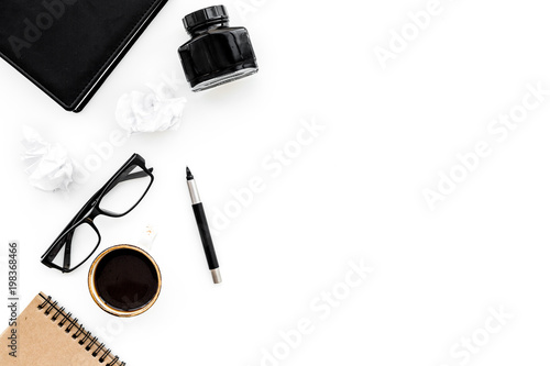 writer office desk with notebook, ink, pen and glasses white background top view space for text