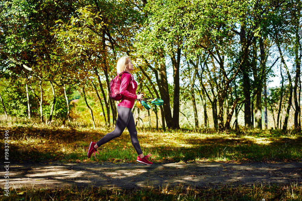 Fit healthy woman with suspension rope running in park Fit healthy woman with suspension rope running in park