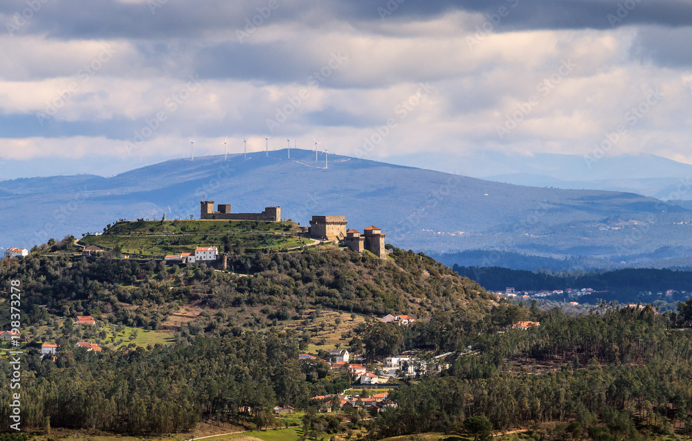 Naklejka premium Landscape with ourém castle and mountains in background on a cloudy spring day, in Portugal. - Paisagem com o castelo de Ourém e montanhas de fundo num dia nublado de primavera, em Portugal.