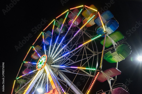 At the amusement park: detail of the night ferris wheel with colored lights