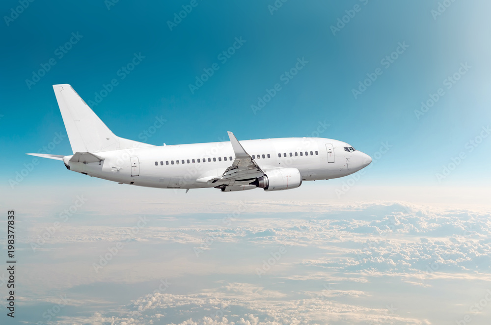 Obraz premium Passenger airplane fly on a hight above overcast clouds and blue sky.