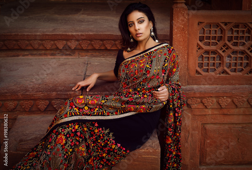 Fotografie beautiful nice woman sit on the stairs in agra at taj mahal