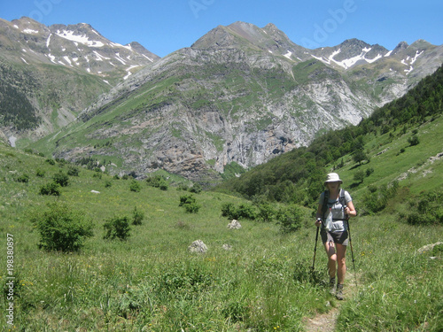 Valle de Ordesa, Pireneje, Hiszpania - dziewczyna wędrująca z kijkami zieloną Doliną Ordesy