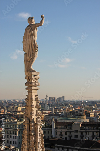 Statue with raised hand on the cathedral of Milan, Italy
