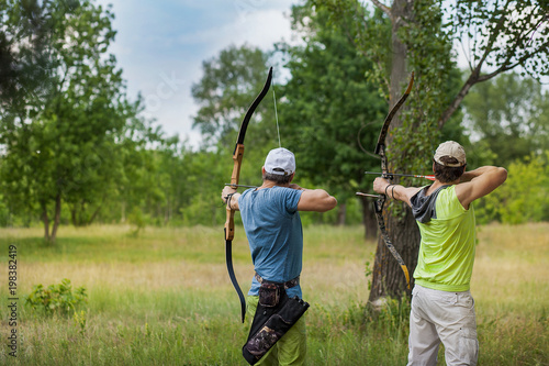 Two men compete in archery on vacation in the forest
