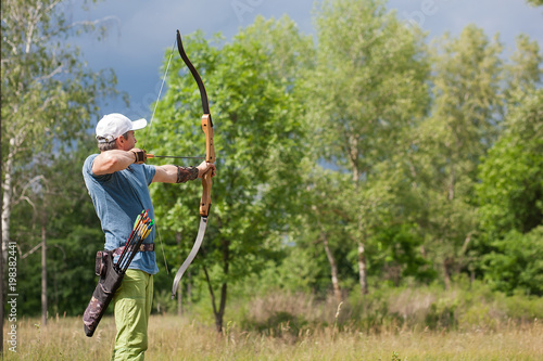 Man shoots an arrow in the forest on vacation