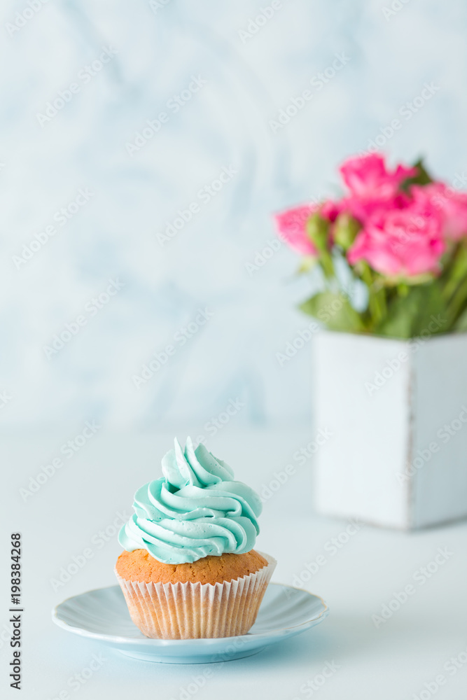 Blue pastel vertical banner with decorated cupcake and bouquet of pink roses in retro shabby chic vase. Blue pastel vertical banner with decorated cupcake and bouquet of pink roses in retro shabby chic vase.