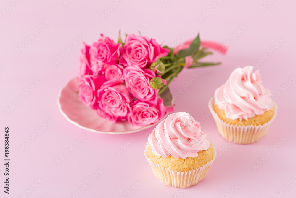 Cupcake with pink cream decoration and roses on pink pastel background. Cupcake with pink cream decoration and roses on pink pastel background.