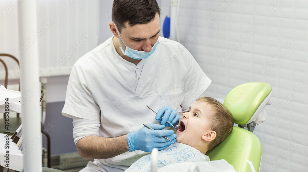 Dentist examining little boy's teeth in clinic. Dental problem. Dentist examining little boy's teeth in clinic. Dental problem.