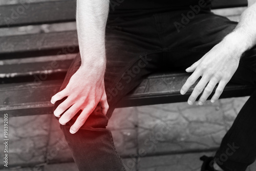 Man holding hands sore knee
