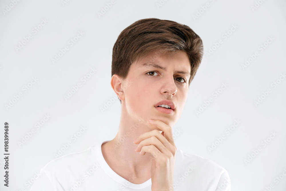 Teenage boy with acne problem on light background Teenage boy with acne problem on light background
