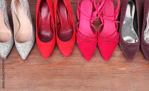 Different female shoes on wooden background