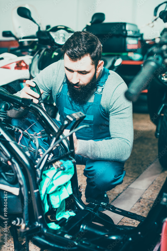 Worker repairing motorbike