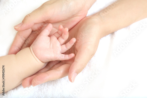 小さな赤ちゃんの手を母の手で包むイメージ