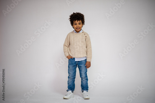 cute Lovely dark-skinned boy with age 6 years in different clothes shows different emotions on different backgrounds