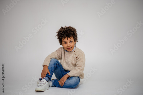 cute Lovely dark-skinned boy with age 6 years in different clothes shows different emotions on different backgrounds © Вячеслав Чичаев