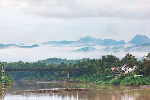 Nam Khan (Khan River) and Old Bridge Beautiful landscape in Luang Prabang. Behind the mountains and morning mist.