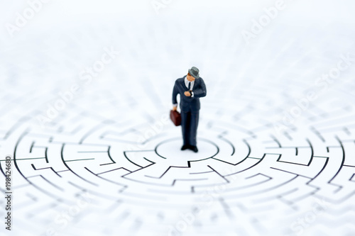 Miniature people : businessman standing on maze,Concepts of finding a solution, problem solving and challenge.