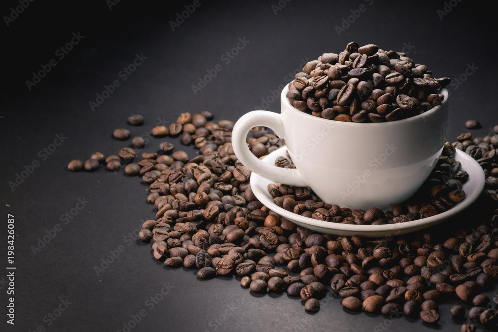 coffee in white cup and coffee beans are the background. coffee in white cup and coffee beans are the background.