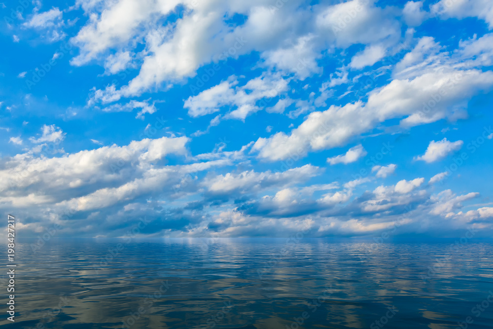 Background of sky and clouds reflected in water or ocean
