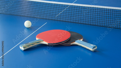 Table tennis black and red rackets on blue table