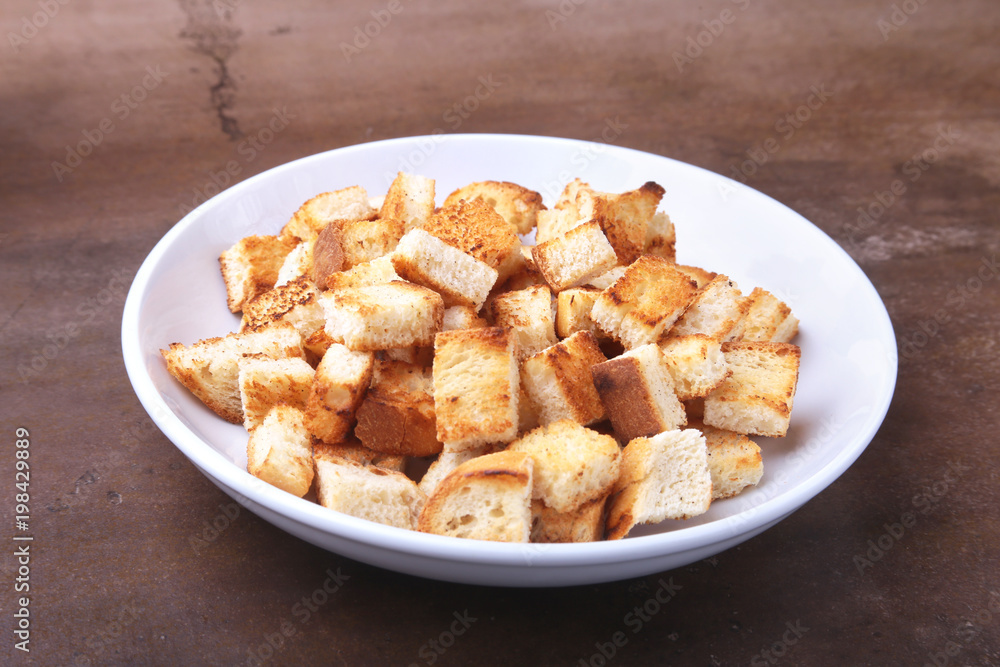 Delicious crispy croutons, crumbs of bread in white plate. ready for cooking. Delicious crispy croutons, crumbs of bread in white plate. ready for cooking.