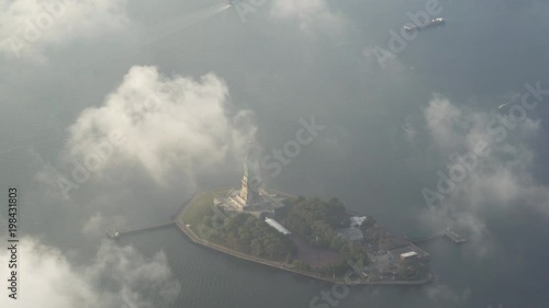 New York City high angle aerial view of the Statue of Liberty at sunsrise with low level clouds below.