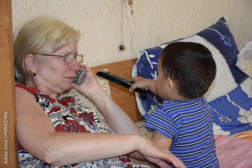кавказская бабушка с латинским внуком в домашней обстановке  