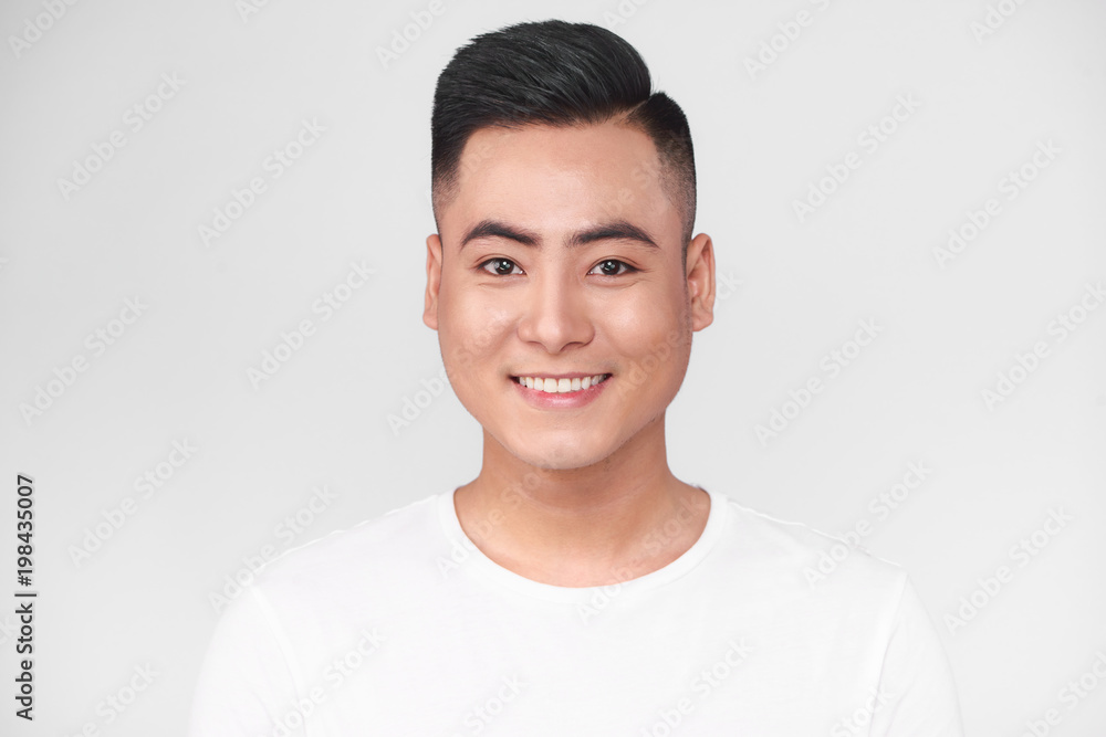 Portrait of handsome young asian man against grey background Portrait of handsome young asian man against grey background