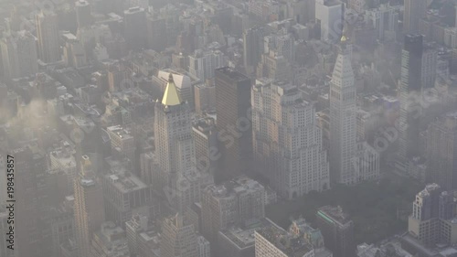 New York City aerial view flying over Madison Square Park and the Flatiron Building at Sunrise.
