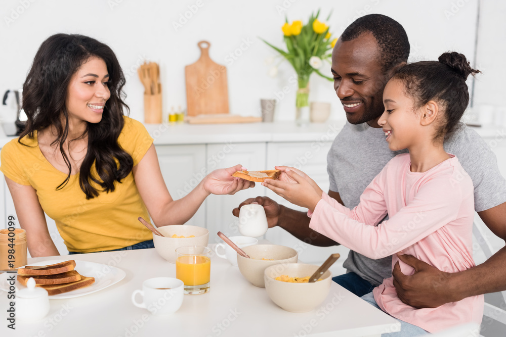 smiling young family having healthy breakfast on kitchen together smiling young family having healthy breakfast on kitchen together