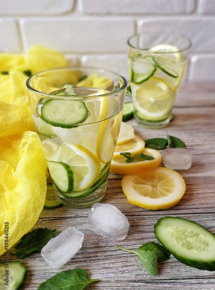 detox water in glass, sliced lemon and cucumber with ice to cleanse the body detox water in glass, sliced lemon and cucumber with ice to cleanse the body
