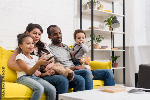 young family watching tv together at living room