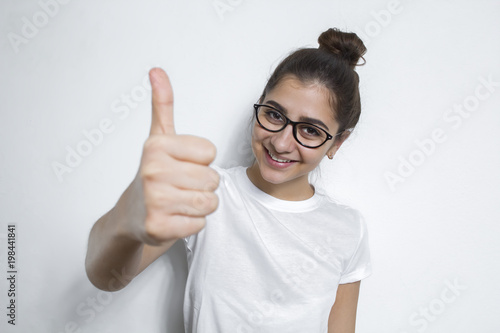 I like  Cheerful happy girl in glasses shows thumbs up on white background. A young Indian woman approves of your choice. Looking at the camera.