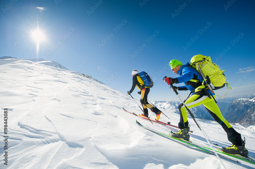Cross country skiing team couple of men towards the summit of the mountain