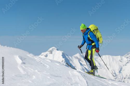 Cross country skiing man alone towards the mountain
