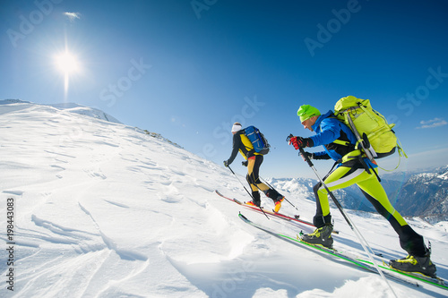 Cross country skiing team couple of men towards the summit of the mountain
