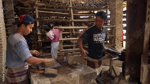 Men and women working at manual clay roof tiles making factory in Kebumen, Indonesia photo