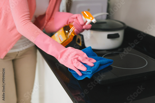 Young asian woman preparing to clean the kitchen. Hand holding detergent spray.