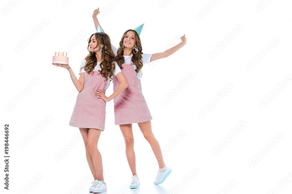 happy beautiful young twins with birthday cake on white happy beautiful young twins with birthday cake on white