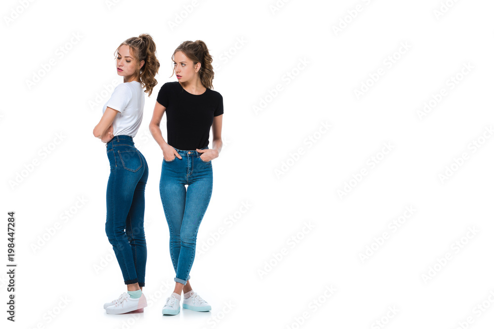 irritated young twin looking at sister isolated on white