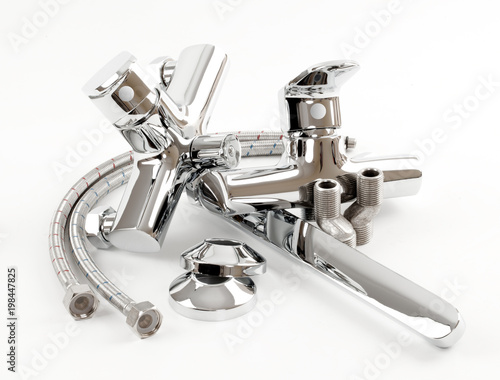 Metal chromed Bathroom Faucets, Hoses, Eccentrics and decorative Reflectors on a white background. Set of parts for the bath mixer