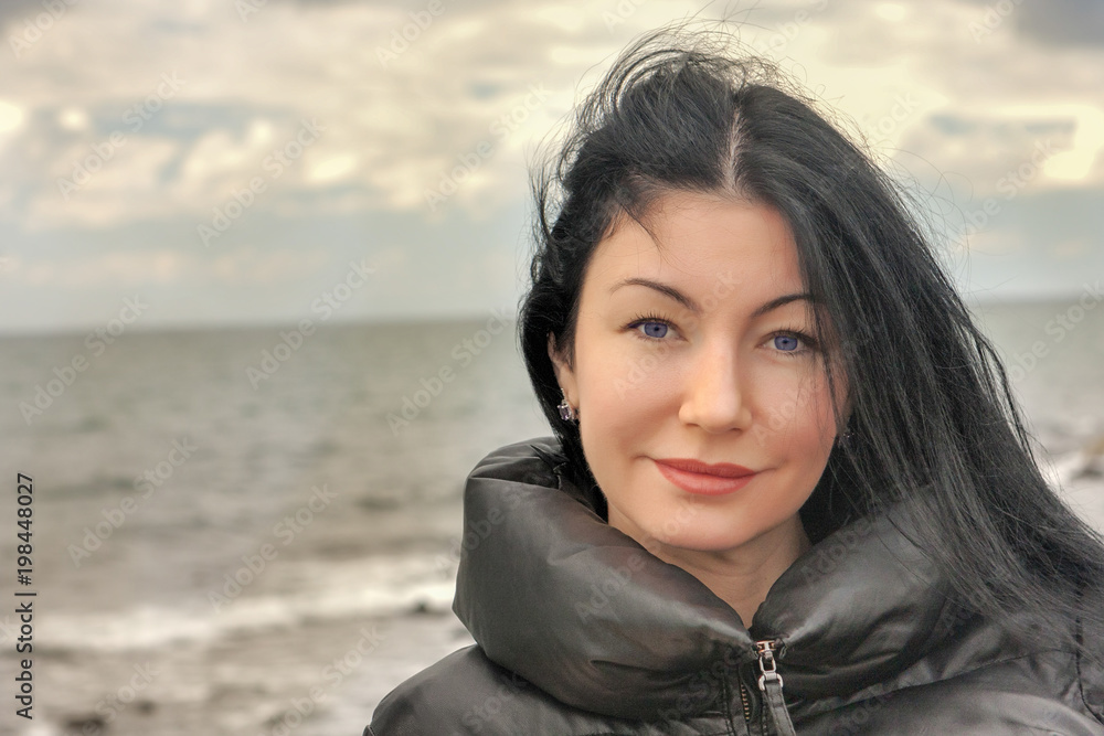 Portrait of a beautiful brunette woman in a winter sea