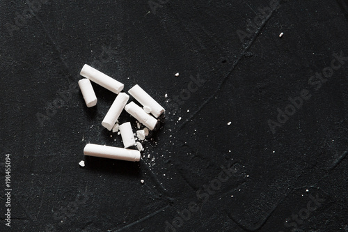 A few pieces of white chalk lie on the board for writing your own work. DIY. Hand made. Copy space..