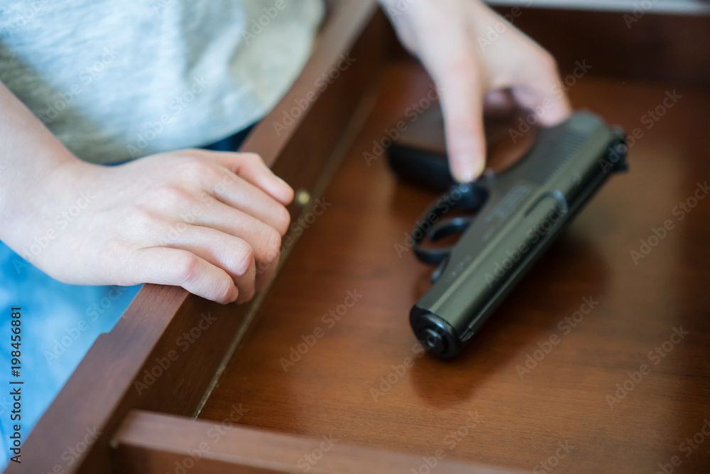 Obraz premium Child found pistol in drawer at home.