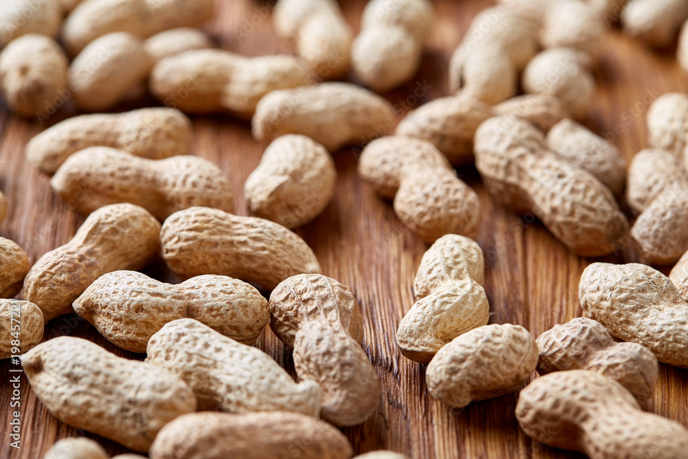 Seamless pattern shelled peanuts isolated on wooden background, top view, close-up, shallow depth of field Seamless pattern shelled peanuts isolated on wooden background, top view, close-up, shallow depth of field