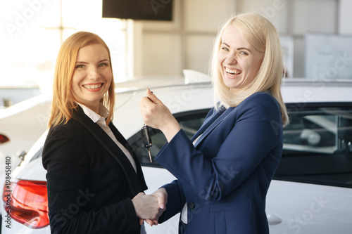 Woman receiving car keys from a dealer photo