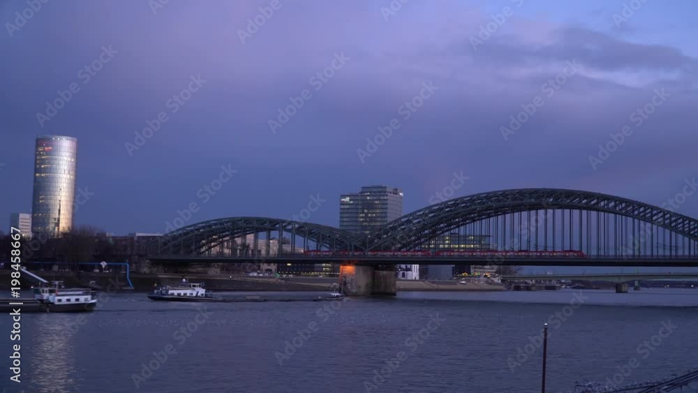 Sunset over the Cologne Skyline Triangle Tower Crowd Pass Bridge Tourists Travel and river Rhine in Cologne, North Rhine-Westphalia, Germany Sunset over the Cologne Skyline Triangle Tower Crowd Pass Bridge Tourists Travel and river Rhine in Cologne, North Rhine-Westphalia, Germany